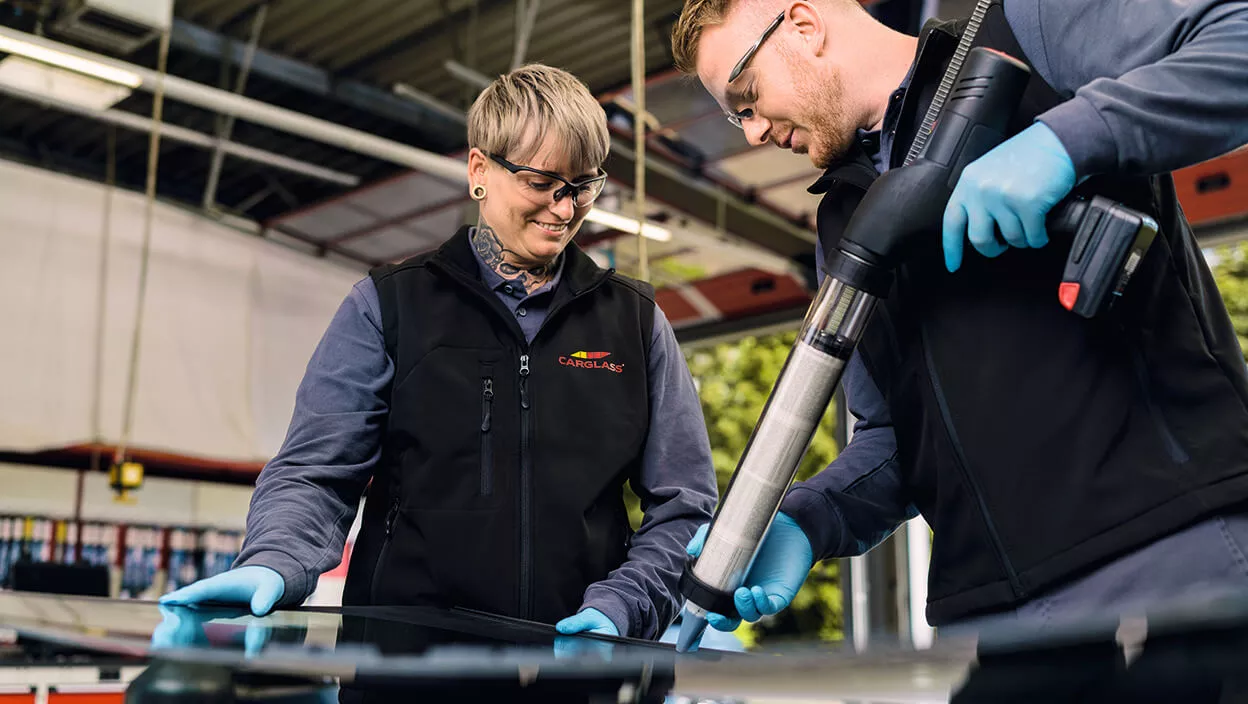 Carglass Mitarbeiter schult neue Kollegin für Scheibentausch ein